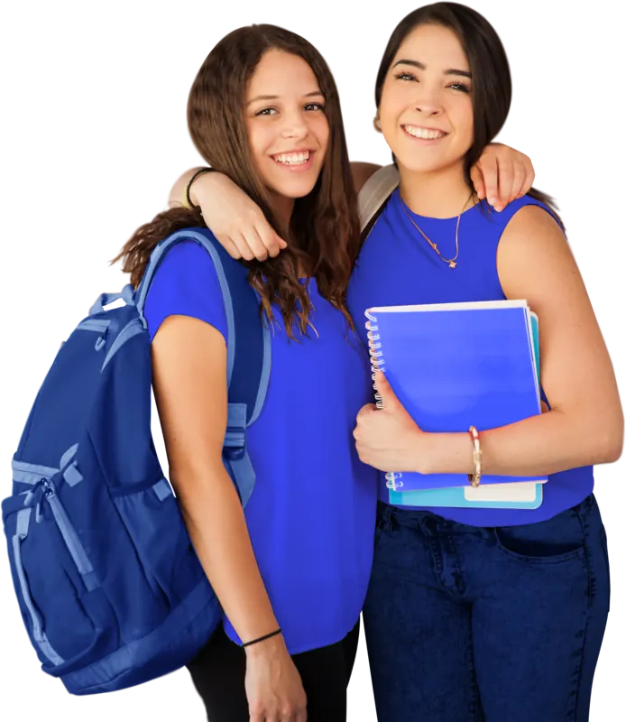 Two smiling students standing arm in arm, one with a backpack and the other holding notebooks